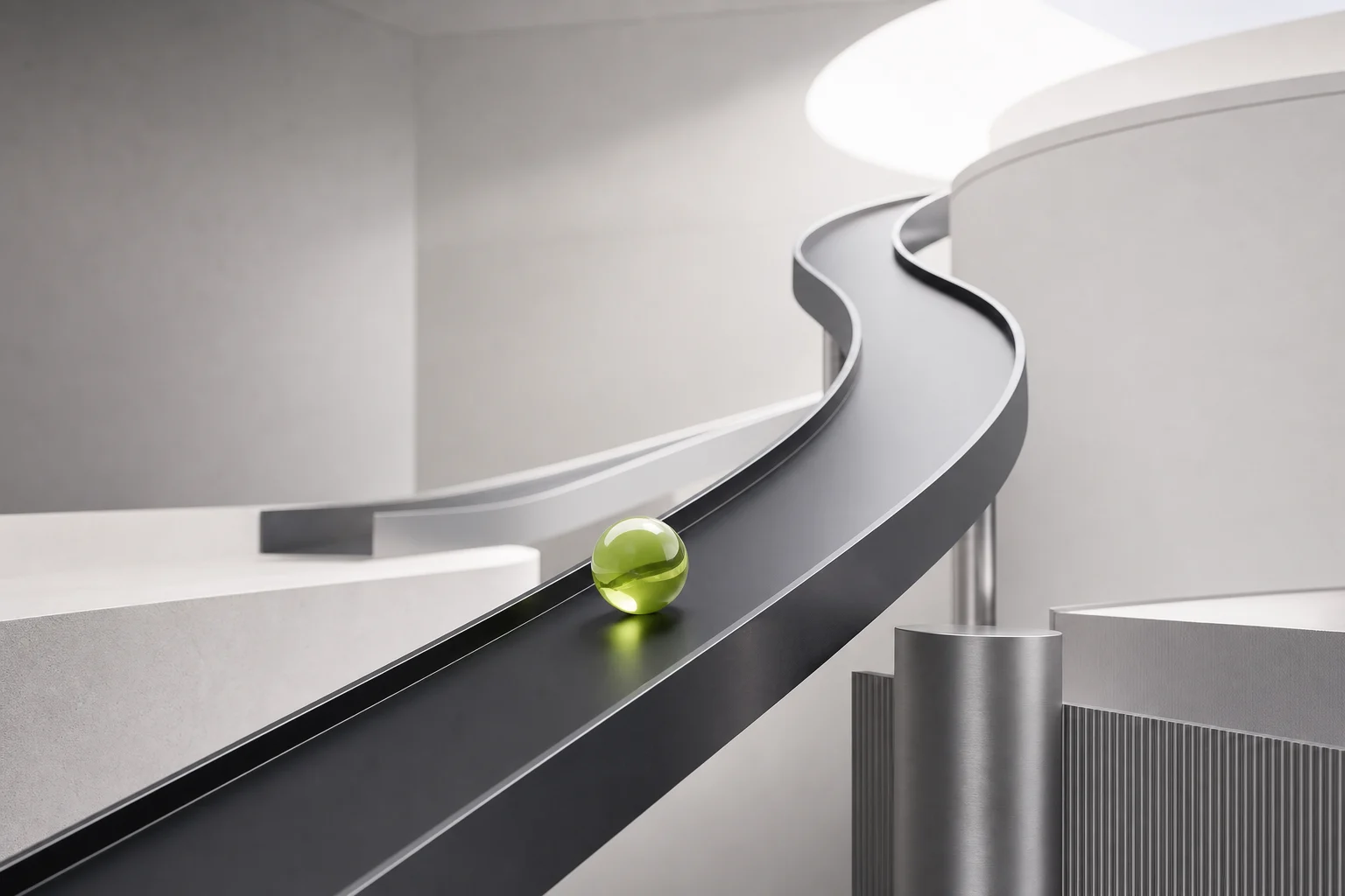 Grüne Glaskugel auf einer ansteigenden schwarzen Bahn in einem hellen Studio